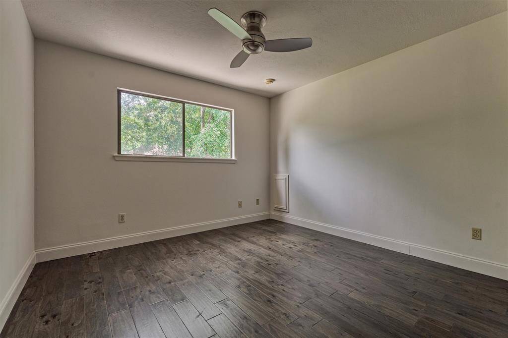 Secondary bedroom #1 features wood flooring, ceiling fan, and closet.