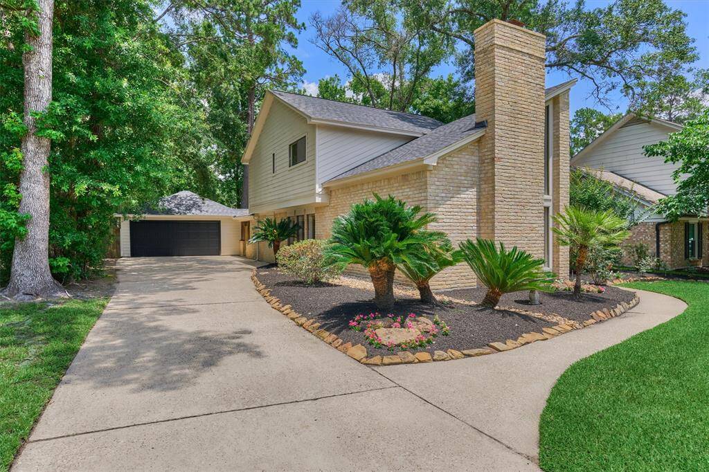 Lush and well-manicured landscaping lead up to 2-car detached, oversized garage with EV charger!