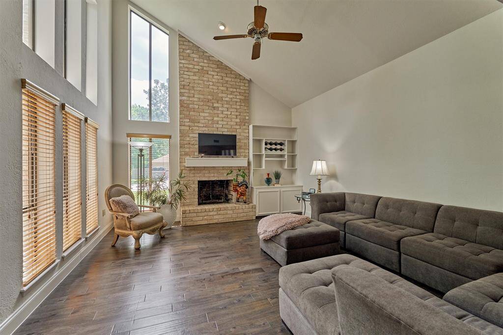 Soaring ceiling and floor-to-ceiling windows flood the den with natural light.