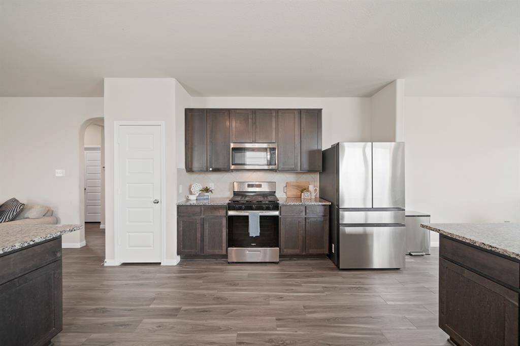 The thoughtful flow of this kitchen makes cooking so easy. Plus, the kitchen features a pantry and the refrigerator is negotiable. Notice the additional storage and prep space around the stainless steel natural gas cooktop and oven.