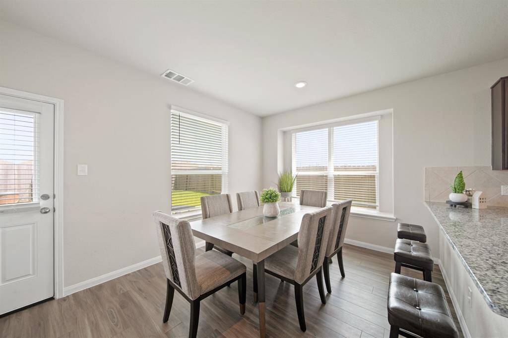 Gather with friends and family in this beautiful dining area, featuring large windows and window seat which could be used for decor, storage or seating.