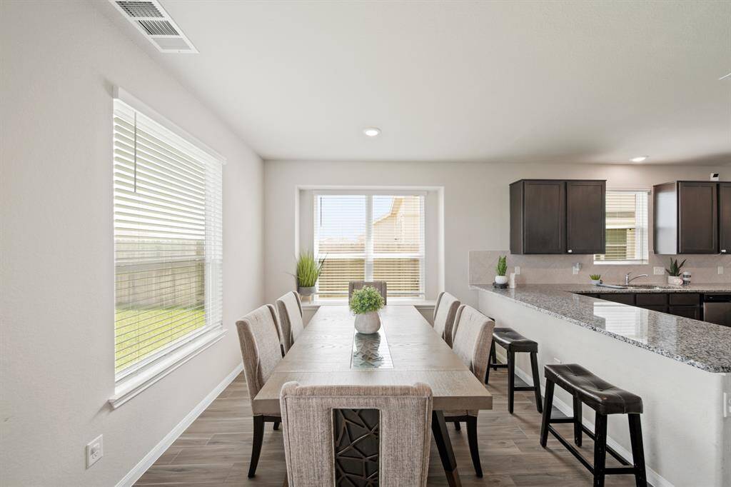 Another view of the generous dining area. (The photo features a table of 6.) Notice the additional seating at the kitchen counter.
