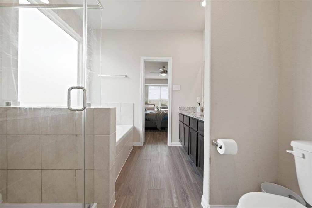 The Primary Ensuite features a spacious and well-appointed primary bathroom with neutral colors, nice storage and waterproof LVP flooring.