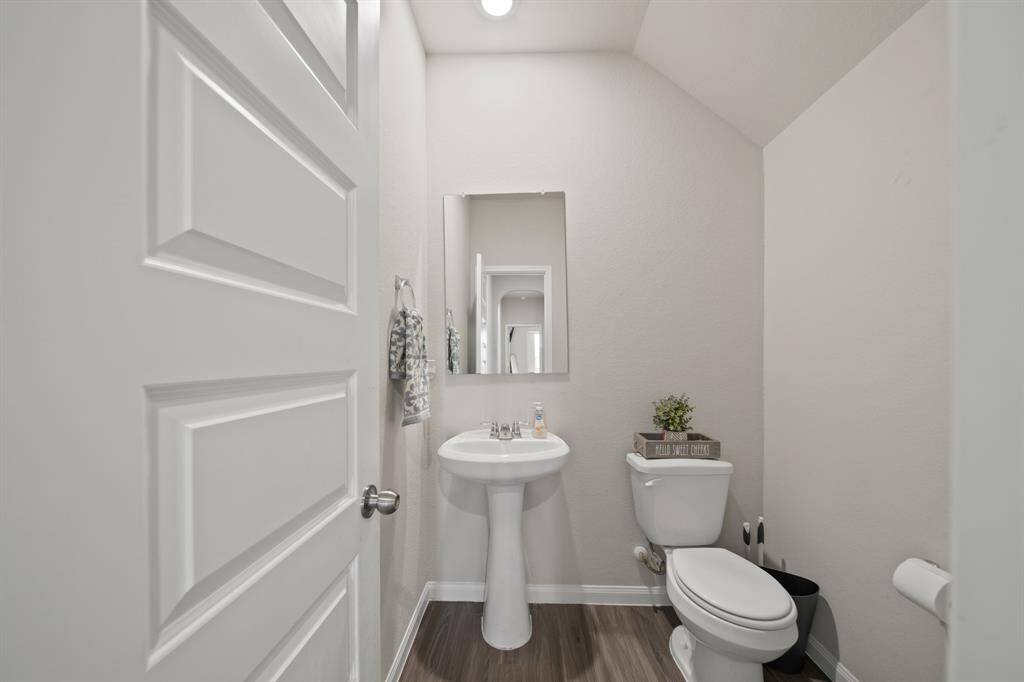 On the first floor, is a large half-bath with pedestal -- perfect for your guests. (Not pictured -- down the hall -- is the walk-in large room featuring shelf storage and hang bars.)