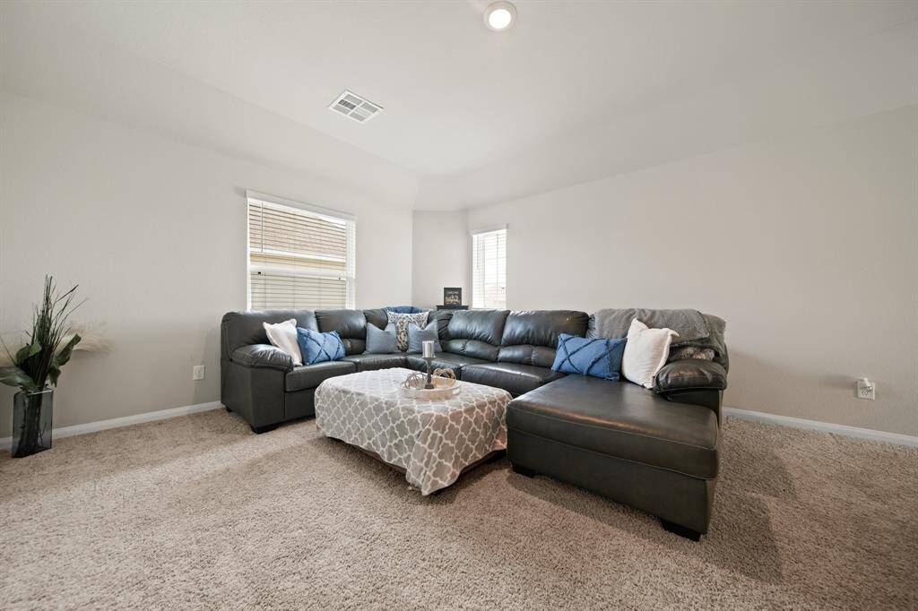 Another view of the spacious game room featuring LED lights and 2 large windows. The neutral colored paint and carpet would compliment any decor.
