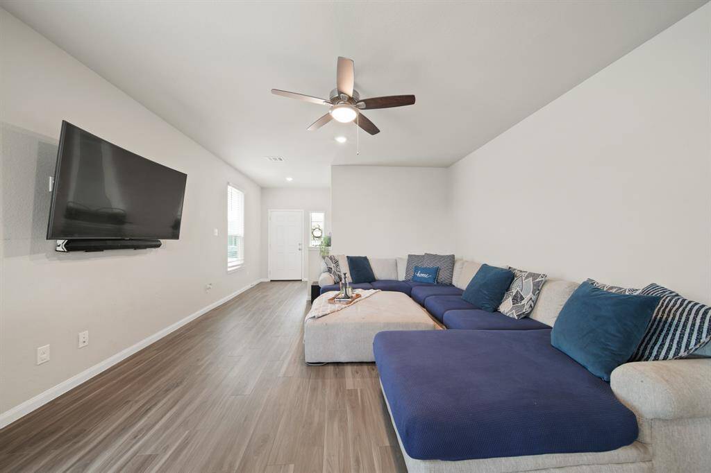 The spacious family room is well designed to accommodate large furniture. The windows with with cordless blinds help bring in so much natural light. And the LED lights and fan are great energy savers in this energy-efficient home.