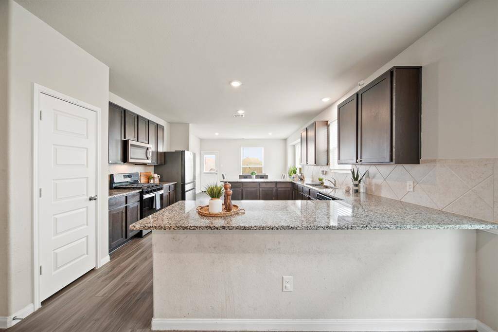 This incredible kitchen is the showstopper of the first-floor. The kitchen features tons of counter space, 42" cabinets, a gas range and a pantry. Add 4 stools and this bar-height counter is the perfect place to enjoy your breakfast.