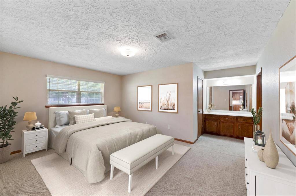 The primary bedroom offers tons of space and a vanity area off to the side.