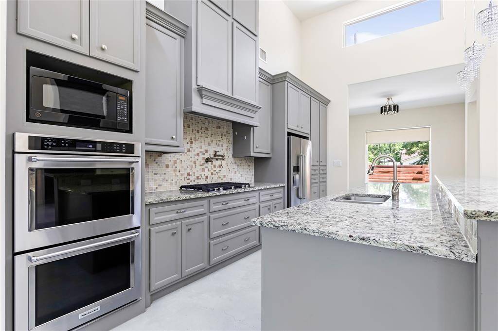 Spacious kitchen with double ovens, propane powered cook-top, ample storage space and granite countertops
