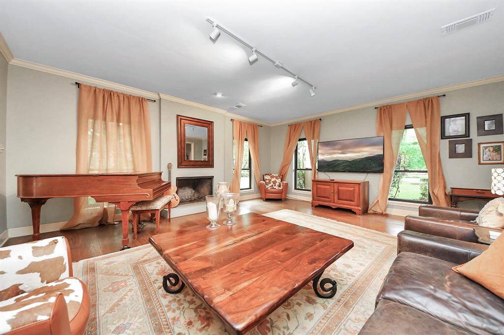 The den is surrounded by windows that bathe the room in natural light and highlight the gorgeous fireplace as a cozy focal point. Easy-care Danish wood floors add timeless warmth underfoot, while brand-new windows throughout the home ensure energy efficiency and comfort year-round. This inviting space is perfect for family gatherings or quiet relaxation.