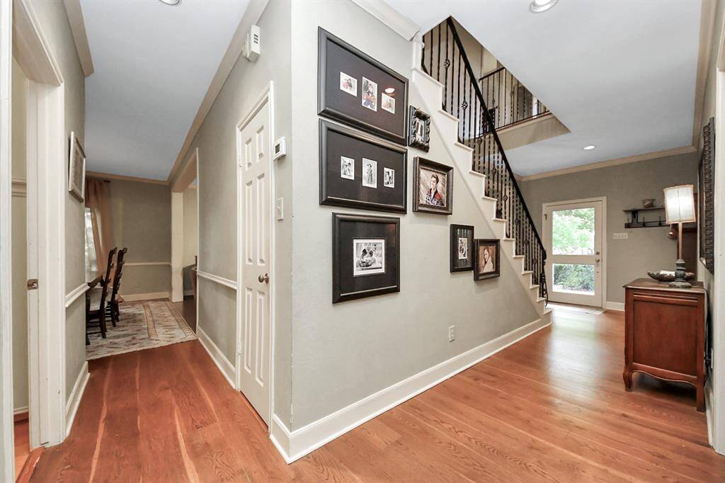 A wall alongside the staircase offers the perfect gallery space for family photos. Convenient under-stair storage is good use of space, while this view showcases the fluent flow of the home’s layout.