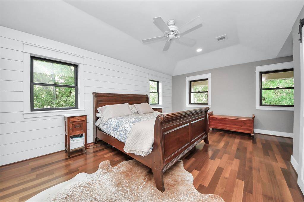 This final view of the primary suite features a crisp white shiplap accent wall and striking dark-cased brand-new windows that frame the natural light beautifully—adding depth and contrast to the space.