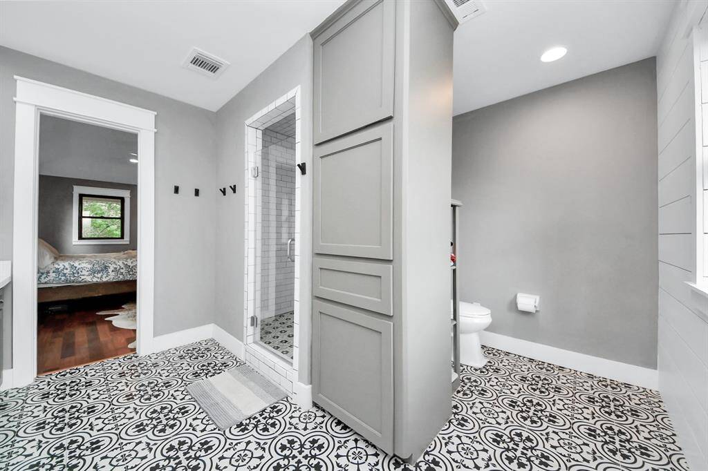 Artfully patterned tile floors set the stage in this luxurious bath, while the spacious walk-in shower offers the perfect place to unwind with a relaxing steam at the end of a long day.