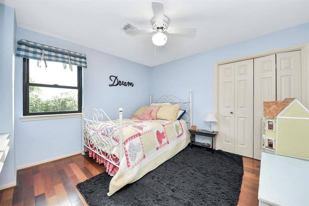 The third secondary bedroom is equally generous in size, with natural light streaming in and warm Brazilian Cherry floors. Whether used as a bedroom, craft room, or quiet reading retreat, the possibilities are endless.