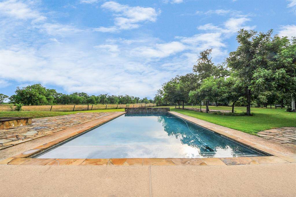 This impressive pool reaches 11.5 feet deep and features a tranquil waterfall and walk-in entrance—perfect for relaxing, swimming laps, or soaking up the sun.