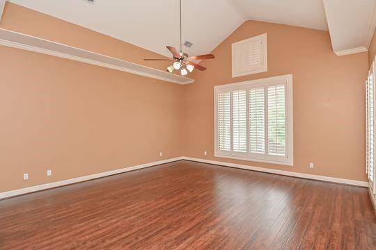 Soaring ceilings and tall windows with plantation shutters in the primary bedroom add to it's charm.