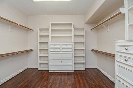 A view of the many built in cabinets in the primary closet.