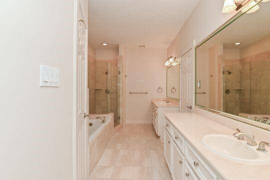 The large executive style primary bath has beautiful marble counters with his and her sinks.