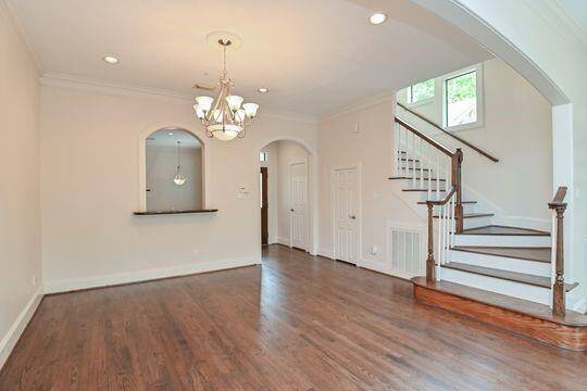 The majestic dining space has high a ceiling, a soaring staircase & ample space for a large dining table.