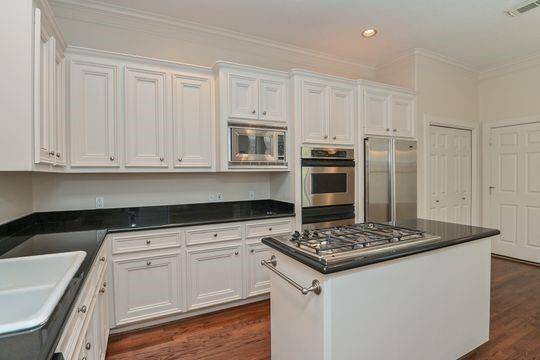 The well arranged kitchen has an island which features the cooktop & extra prepping space.