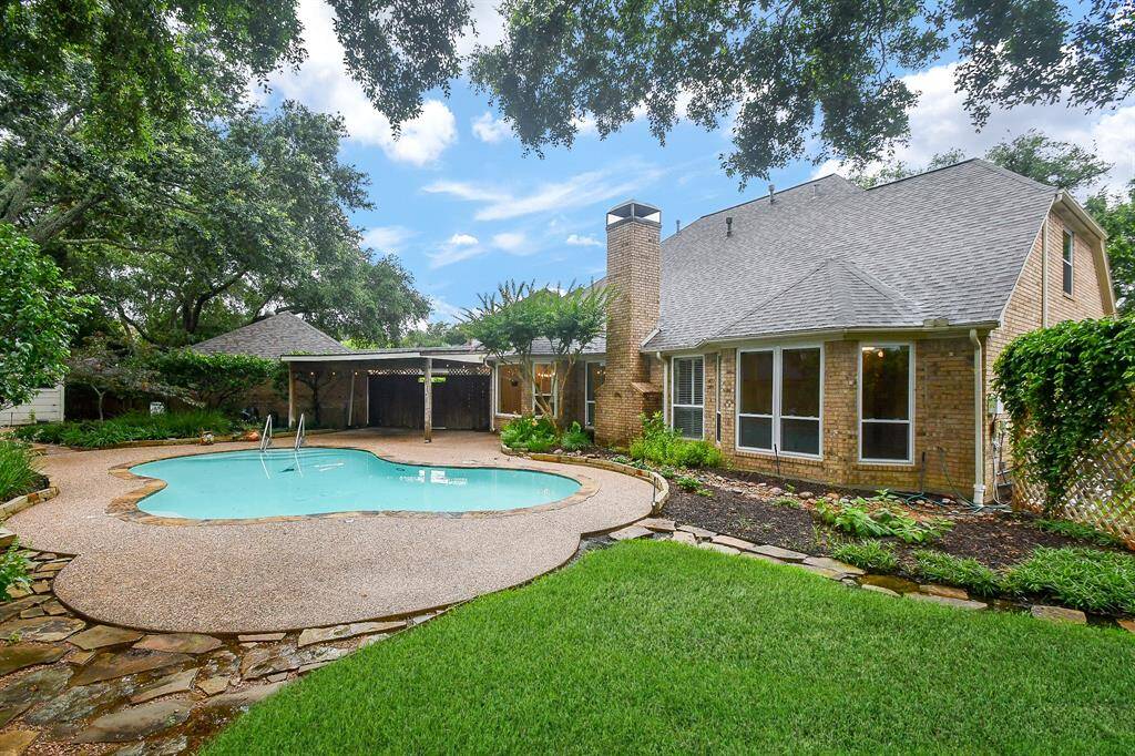 a Huge Backyard with a Large Pool, a covered back patio and plenty of grass areas out back!