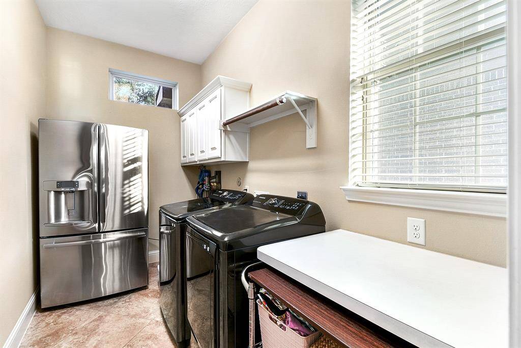 Large utility room with room for an extra fridge or deep freeze, cabinet space and countertop.