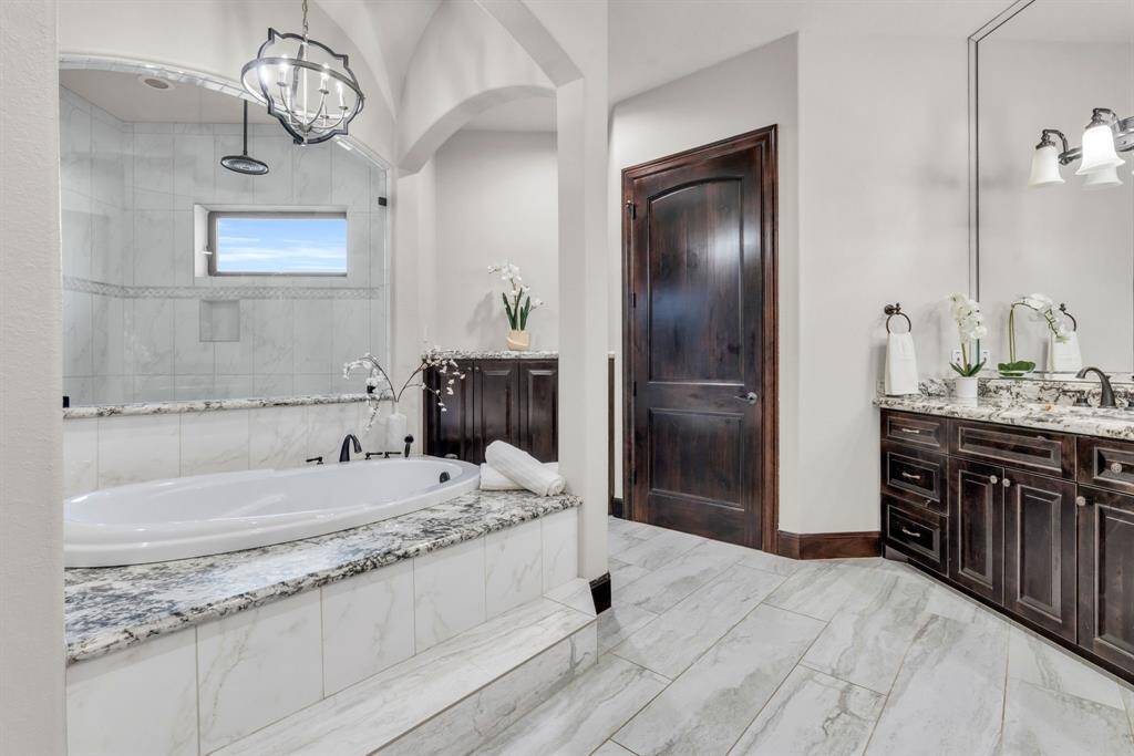 The Primary Ensuite provides Dual Sinks, Granite Countertops, a contemporary shower enclosure w/glass & modern trim & a Oversized Jetted Tub!! 5912 T St., Katy, TX  77493