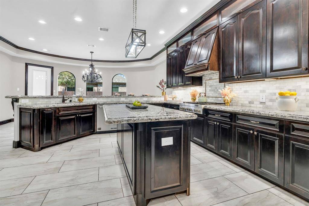 This Gourmet Kitchen features custom cabinets, recessed & pendant lighting, and granite countertops with a breakfast bar, which allows for extra seating for you & your guests! 5912 T St., Katy, TX  77493