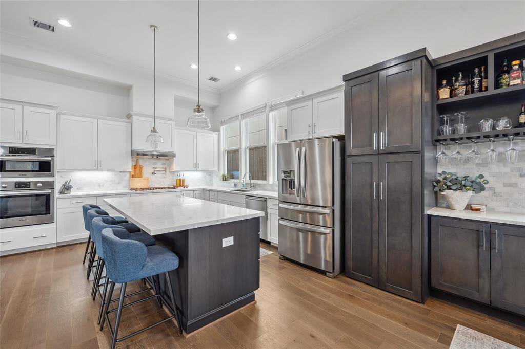 Notice addition of cabinets to right of refrigerator and custom bar addition