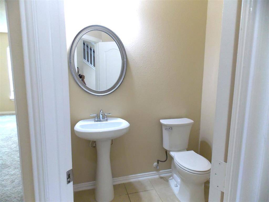 This bathroom features a dual-sink vanity with a large mirror, white cabinetry, and a neutral color scheme, offering a clean and functional space.