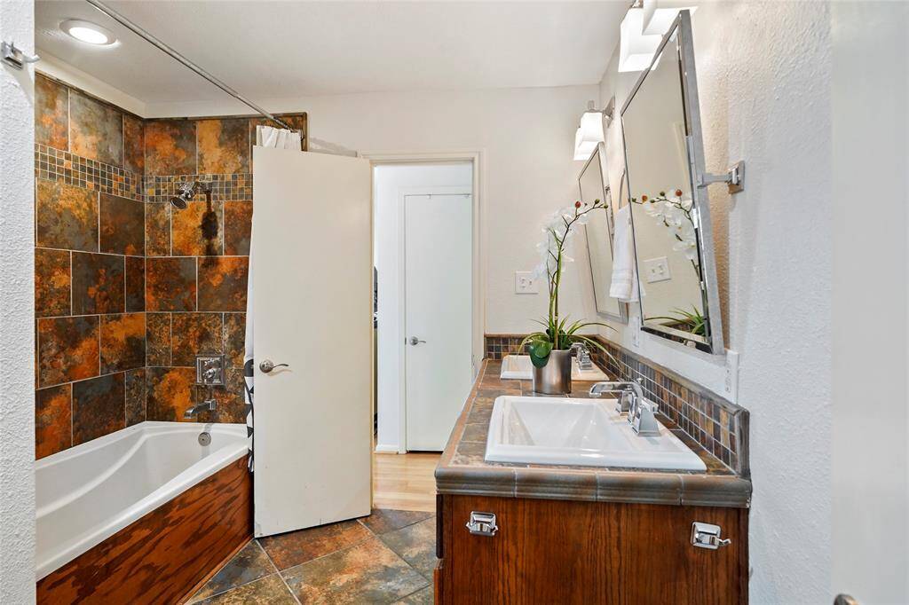 Your primary ensuite bath with double vanity and tub/shower combo.