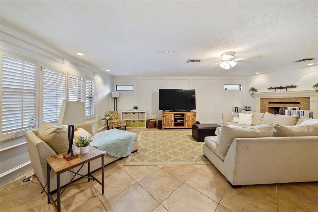 This open living room features easy to maintain tile flooring, loads of windows, directional lighting, and is easy for entertaining.