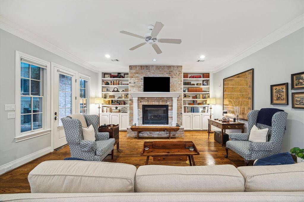 A cozy brick-surround fireplace centers the open-concept family room, blending warmth with seamless flow for effortless everyday living.