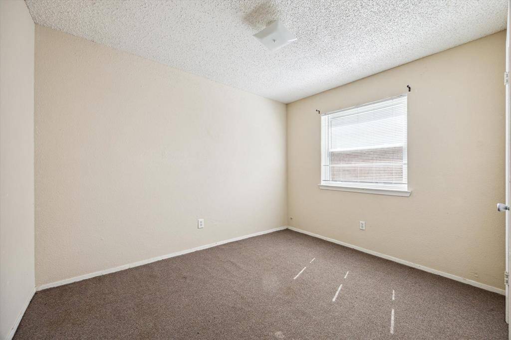 Inviting bedroom with soft carpet and generous natural light, offering a warm and tranquil space for relaxation.