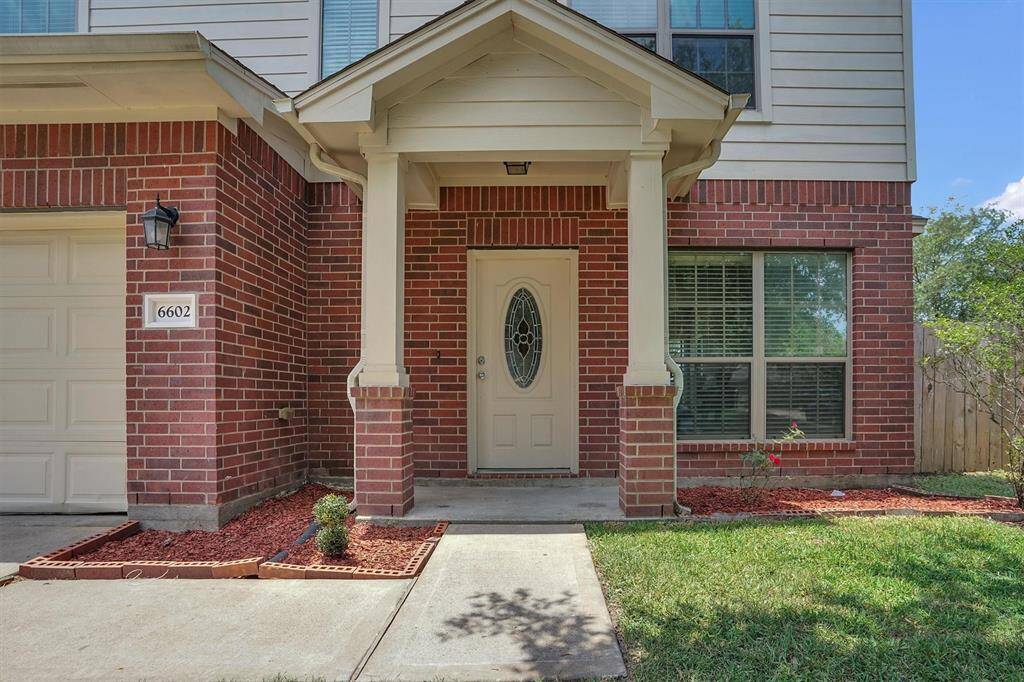 Charming brick-front home with a welcoming covered entrance. Features a decorative front door, large window for natural light, and neat landscaping with red mulch accents. Ideal for buyers seeking curb appeal and a cozy entryway.