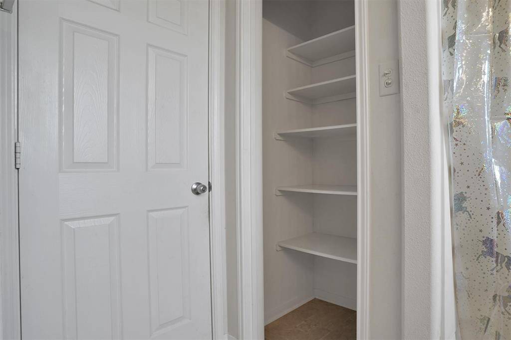 This photo shows a small closet with multiple shelves, ideal for storage.