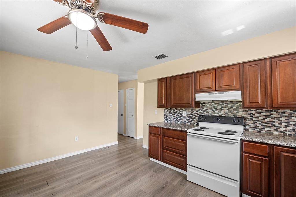 Granite countertops and a decorative backsplash accent the kitchen.