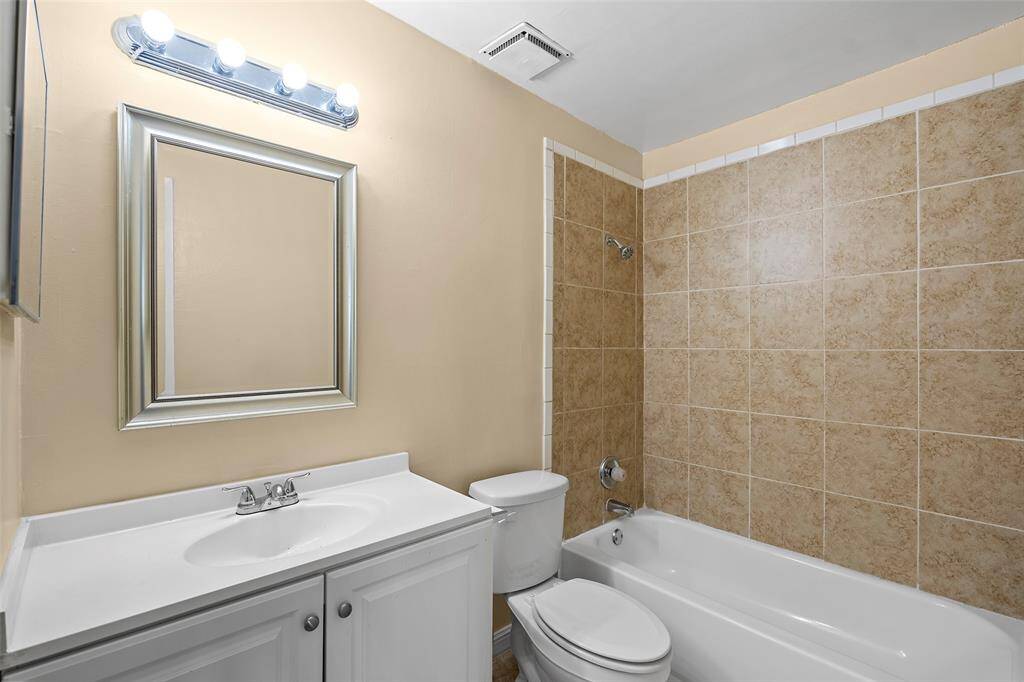 Tiled shower tub combo with cabinet for all your storage needs.