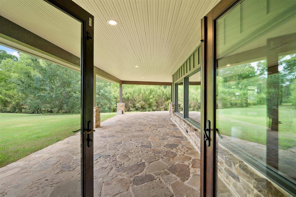 “Unbelievable” is an apt description of this wrap-around covered Porch. Impressive in width measuring 14-feet wide and beautifully finished with a flagstone floor that washes up the wall, matching stone columns and a finished bead-board ceiling.