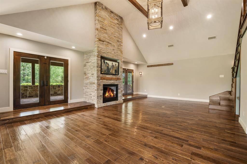 The massive Family Room is an architectural masterpiece where the eye is first drawn upwards to the cathedral ceiling accented with designer chandelier and exposed beams that complement the wood floors.