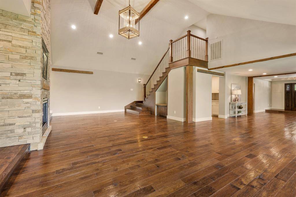 This view showcases design excellence that transforms what would be a normal staircase into a work of art and another focal point of the room. The opening to the Wet Bar is glimpsed by the sofa table.