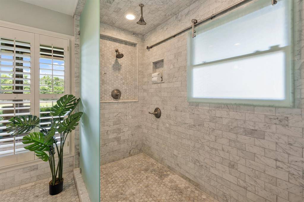 Yet, another masterpiece in design and finishes. Carrea marble tile floors flow into the amazing shower that is fully encased in gorgeous tile and finished with 2-rainhead showers, a shampoo niche and a window with a one-of-a-kind sliding privacy glass.