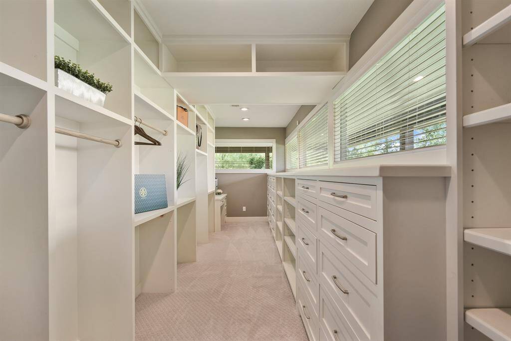 If “big is better”, you will love this exceptional walk-in Closet! Measuring over 23-feet long, it offers plenty of hanging space, lots of pull-out drawers and shelving for storage and shoes. The entire length also has transom windows that naturally light the space while providing remarkable views.