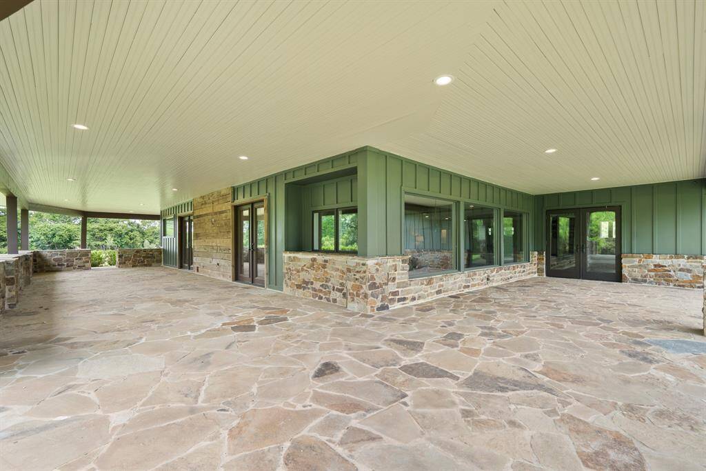 This magnificent covered Porch offers year-round enjoyment and enough covered space to hold even a large wedding reception!  Or orientation, the double doors on the right open to the Kitchen and the other 2-other pairs lead to the Family. There is also the covered Porch that stretches along the front of the house, together providing 360-degrees of covered space to offer sunrises to sunsets.