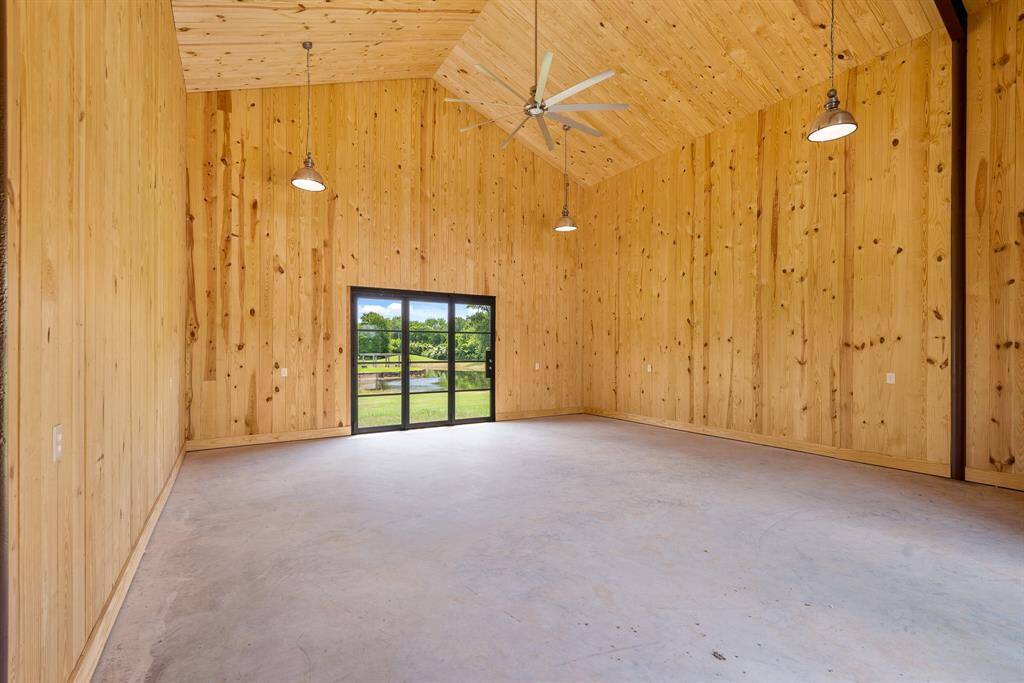 Here’s a look inside. The backdoor is an exact match of the glass front door and when opened, allows the space to be completely open from front to back. The 23x23 room is finished in wood with 4-metal chandeliers and a huge ceiling fan to cool the room. It is perfect for a “Party Room”, workshop or a working Office.