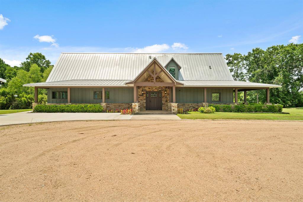 The home looks like it’s right off the cover of a Texas Hill Country magazine, complete with a metal seamed roof, wrap-around covered Porch with stone based columns.