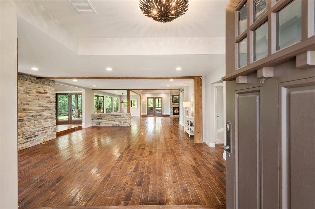A stately front door opens to the raised Foyer and the eye is immediately drawn thru the length of the home to the double French Doors that lay beyond in the Family Room.