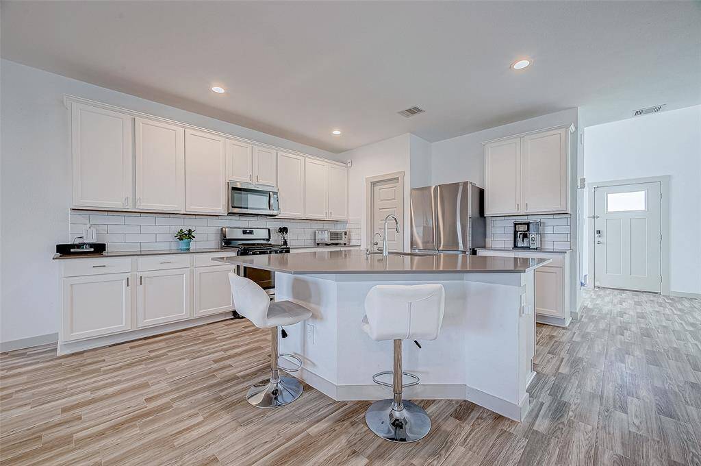 This sleek and spacious kitchen isthe centerpiece of the home,featuring a striking island thatdoubles as a casual dining area.