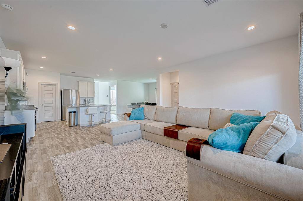 The open layout easilyaccommodates ample comfortableseating, while recessed lighting addsto this living room's charm.