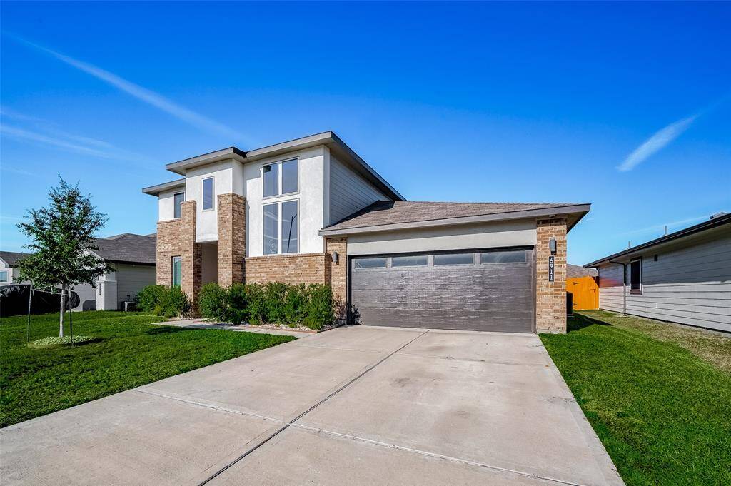 The expansive front yard, lushgreenery, and wide driveway createa welcoming first impression.